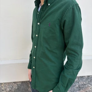Polo Ralph Lauren skjorta - Snygg grön skjorta från Ralph Lauren i slim fit. Skjortan har långa ärmar och knappar framtill. Perfekt för en stilren look.