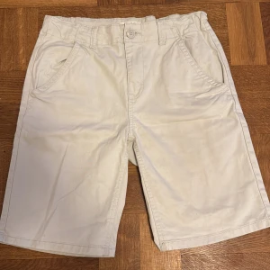 Shorts - Säljer ett par stilrena beige shorts från Lindex. De har en klassisk design med knapp och dragkedja framtill samt praktiska fickor på sidorna. Perfekta för en avslappnad sommarstil.