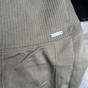 Gröna leggings från Aim'n - Snygga gröna leggings från Aim'n med medelhög midja och ribbade detaljer. Perfekta för träning eller en avslappnad dag. Materialet är stretchigt och bekvämt, vilket ger en bra passform och rörelsefrihet.