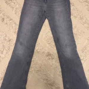 Grå bootcut jeans från ONLY - Snygga grå bootcut jeans från ONLY. De har en klassisk design med en bekväm passform och är perfekta för en avslappnad stil. Midjan är normal och de har en dragkedja framtill. Passar s med🥰