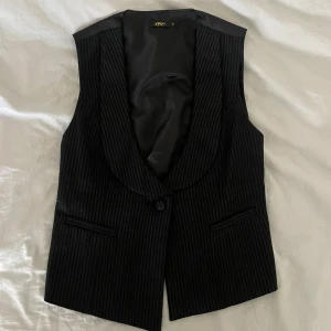 Svart randig väst från Eve - Snygg svart väst från Eve med diskret randigt mönster. Köpt runt 00 talet men i bra skick. 