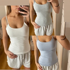 Tre linnen i olika färger - Säljer tre linnen i vitt, ljusblått och grått. Alla har smala axelband och en tight passform, perfekta för sommaren. Materialet är mjukt och stretchigt för extra komfort. Perfekt basplagg för garderoben!