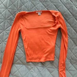 Orange långärmad topp från Amisu - Säljer en snygg orange långärmad topp från Amisu. Toppen har en fyrkantig halsringning och är perfekt för att liva upp garderoben. Passar bra till både jeans och kjol. Hör av dig vid intresse! 🧡