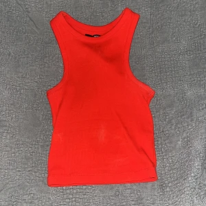 Röd ribbad linnetopp - Snygg röd ribbad linnetopp perfekt för sommardagar. Den är ärmlös och har en enkel design som gör den lätt att matcha med olika outfits.