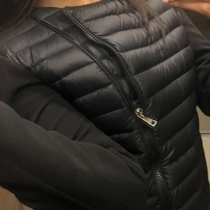 Svart cardigan från Moncler M/S - Snygg svart dunväst från Moncler med dragkedja framtill. Perfekt för lager-på-lager under kyligare dagar. Västen har en stilren design med Monclers logotyp på sidan. Vid snabb affär går pris att diskuteras