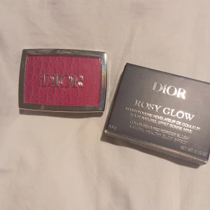 Dior Rosy Glow Blush - Dior Rosy Glow Blush i en vacker rosa nyans. Denna rouge kommer i en elegant silverfärgad dosa med spegel och har en präglad logotyp på pudret. Perfekt för att ge kinderna en naturlig och frisk glöd.