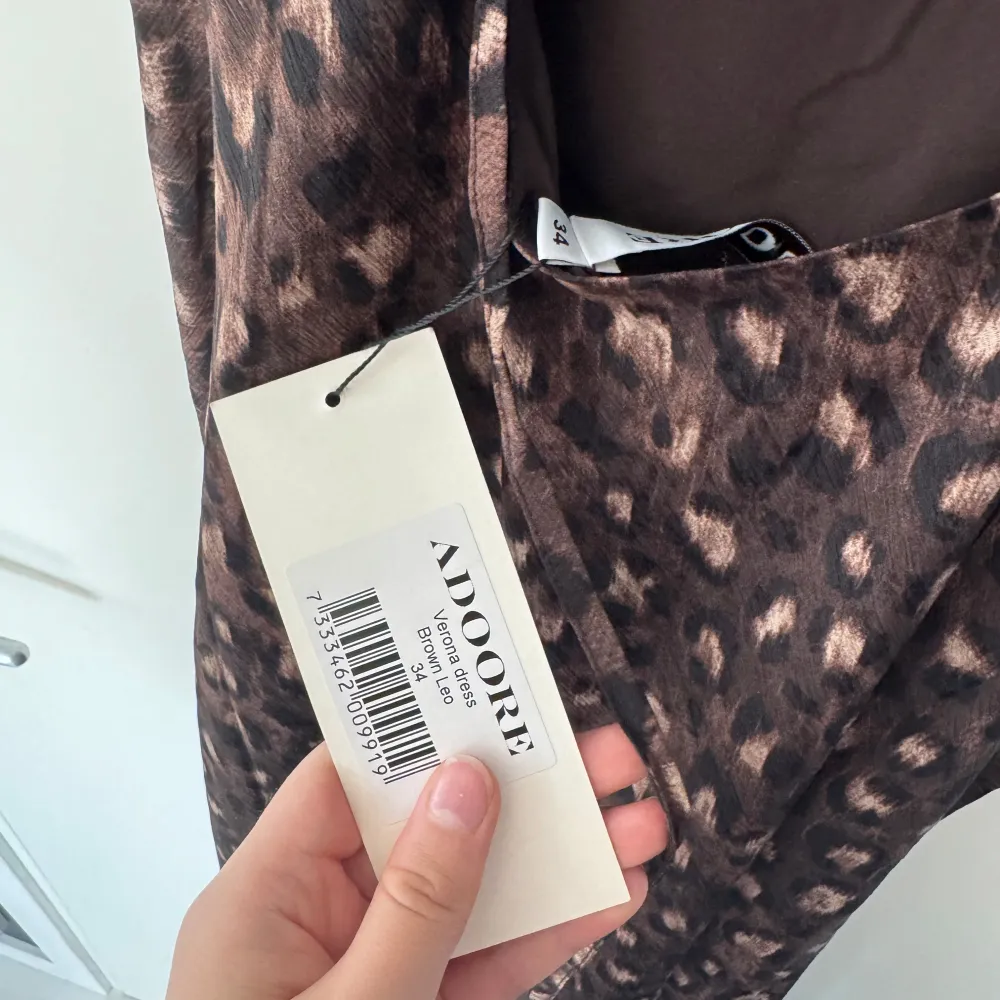Snygg brun leopardmönstrad klänning från ADOORE med smala axelband och en elegant passform. Perfekt för att sticka ut med stil. 🐆. Mekot.