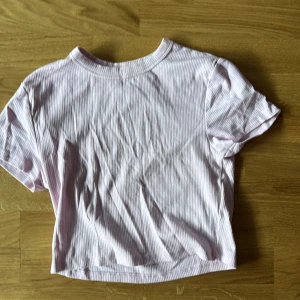 Ljusrosa randig t-shirt från FSBN Sister - Säljer en ljusrosa randig t-shirt från FSBN Sister. Den har en ribbad struktur och korta ärmar. Perfekt för en avslappnad stil. 🌸