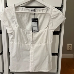Vit topp från Weekday - Säljer en stilren vit topp från Weekday. Nypris 400kr men säljer för 350 då den är oanvänd, kan tänkas gå ned i pris vid snabbt köp ❤️