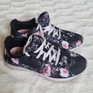 Svarta blommiga sneakers - Snygga svarta sneakers med ett blommigt mönster i rosa och vitt. Se bilder för skick.