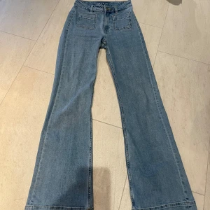 Blå jeansbyxor från Bikbok - Snygga blå jeansbyxor från Bikbok med hög midja och bootcut-stil. Byxorna har framfickor och en klassisk dragkedja med knapp. Använd en gång.