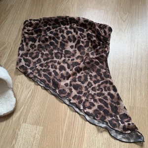 Leopardmönstrad asymmetrisk tröja - Snygg leopardmönstrad tröja med asymmetrisk design. Perfekt för att ge en djärv touch till din outfit. Tröjan har en luftig känsla och är lätt att matcha med olika byxor eller kjolar.