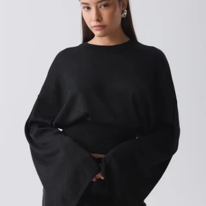 Svart glittrig tröja från Gina Tricot - Säljer en stilren svart glitter tröja från Gina Tricot. Tröjan har en enkel design med långa ärmar och en bekväm passform. Tröjan är tajt runt midjan och lösare vid övre kroppen Perfekt för att matcha med olika outfits.