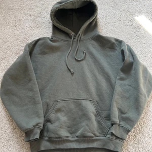 Grön hoodie från BikBok - Säljer en stilren grön hoodie från BikBok i storlek XS. Den har en klassisk design med känguruficka och justerbar huva. Perfekt för en avslappnad look.