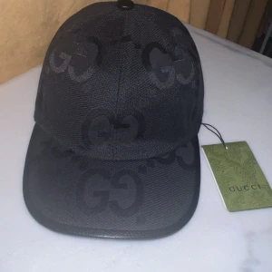 Gucci keps - Snygg svart keps från Gucci med det ikoniska GG-mönstret. Köptes från Milan i Italien för 350€ och är stilren. Passar med allting. Kepsen är helt ny och aldrig ändvänd. Säljer den billigt för att den inte passar mig. PRIS KAN DISKUTERAS!