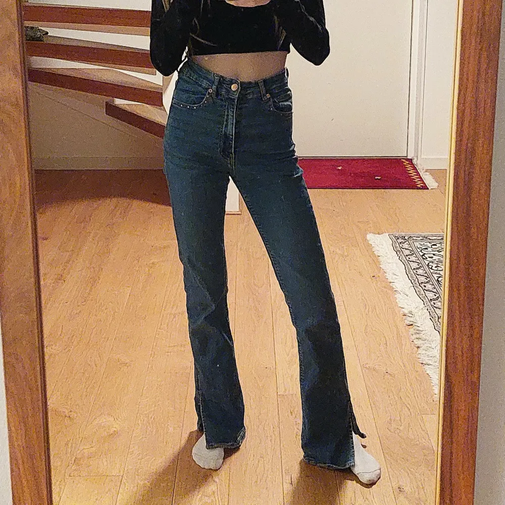 Snygga blå jeans med hög midja och bootcut-stil och slit längst ned. De har broderade blommor på bakfickorna och små rosa och vita diamanter längs linningen. Jeans materialet är stretchigt och fromar sig efter just dig, passar XS-S. Perfekta för en trendig look! Hör av dig om du har fler frågor!💕. Farkut & Housut.