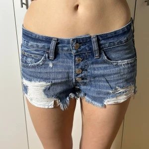 Lågmidjade jeansshorts med hål abercrombie & fitch - W26, kan även passa större då de är stora i storleken. midjemått 38. Köp sker via köp nu, jag postar inom 24h. Kvar tills markerad såld 