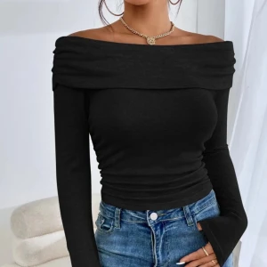 Svart offshoulder topp - Snygg svart offshoulder topp med långa ärmar. Perfekt för en stilren look, den har en åtsittande passform som framhäver figuren. Tillverkad i ett mjukt och stretchigt material för extra komfort.