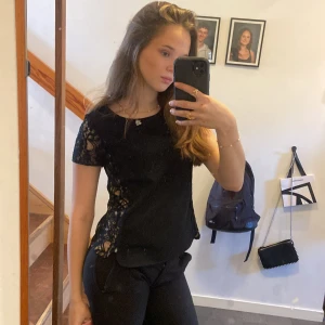 Svart spetsblus - Snygg svart blus med spetsdetaljer på ärmar och sidor. säljer eftersom den inte kommer till användning❤️🥰