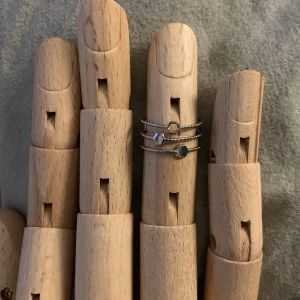 Set med tre silverringar - Snyggt set med tre tunna silverringar. Varje ring har en unik geometrisk form på toppen, vilket ger en modern och stilren look. Perfekt för att bära tillsammans eller separat för en minimalistisk stil.
