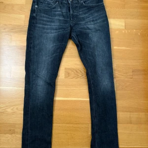 Svarta jeansbyxor från Dondup - Snygga svarta jeansbyxor från Dondup med en klassisk femficksdesign. Byxorna har en rak passform och är tillverkade i Italien. Perfekta för en stilren look. Sprillans nya, modell George 