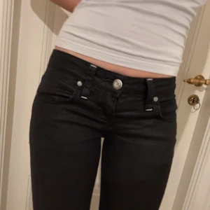 Lågmidjade svarta jeans - Jätte snygga lågmidjade svarta jeans med like läder effekt. Midja: 37 cm innerben: 83! (Lånade bilder)