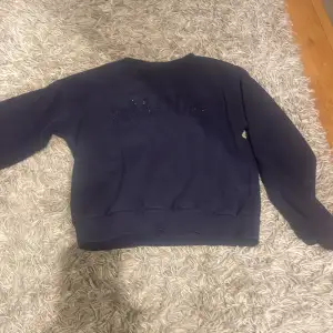Säljer en mörkblå sweatshirt från Gina Tricot med textdetalj på framsidan . Tröjan har långa ärmar och en rund halsringning. Perfekt för en avslappnad stil. 🖤