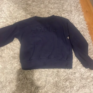 Mörkblå sweatshirt från Gina Tricot - Säljer en mörkblå sweatshirt från Gina Tricot med textdetalj på framsidan . Tröjan har långa ärmar och en rund halsringning. Perfekt för en avslappnad stil. 🖤