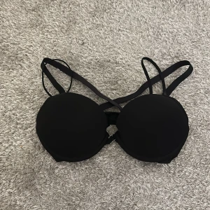 Svart bikiniöverdel från H&M - Snygg svart bikiniöverdel från H&M med vadderade kupor och justerbara axelband. Perfekt för en stilren look på stranden eller vid poolen. Enkel och klassisk design som passar till det mesta.