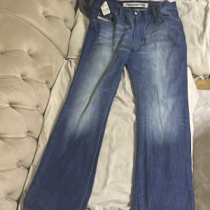 Blå jeans från Diesel - Säljer ett par klassiska blå jeans från Diesel med en snygg tvätt och raka ben. De har en traditionell femficksdesign och en knappgylf. Perfekta för en avslappnad stil. Pris kan absolut diskuteras 