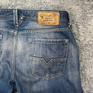 Snygga blå jeans från Diesel med klassisk femficksdesign och en cool tvättad look. De har en knappgylf och en läderpatch med Diesel-logga på baksidan. Perfekta för en avslappnad stil. Skriv vid frågor! 