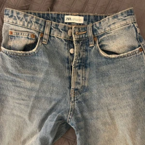  jeans  - Snygga blå jeans från ZARA med en klassisk femficksdesign och knappgylf. Jeansen har en ljus tvätt och raka ben med råa kanter vid bensluten för en trendig look, jätte fina låg midjade använt några gånger ser ut som nya 