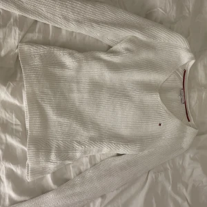 Vit stickad tröja från Tommy Hilfiger - Hyfsad tajt passform, knappt använd. Nypris: 999:-