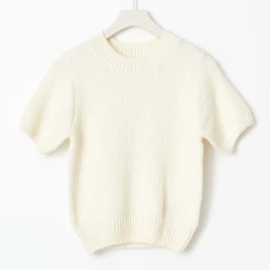 Vit stickad kortärmad tröja - Supermjuk och fluffig vit stickad tröja med korta ärmar och ribbade muddar. Tröjan har en rund halsringning och en något croppad passform som ger en fräsch och modern look. Perfekt att styla med jeans eller kjol för en clean vibe. Använt en gång, ny pris 300kr