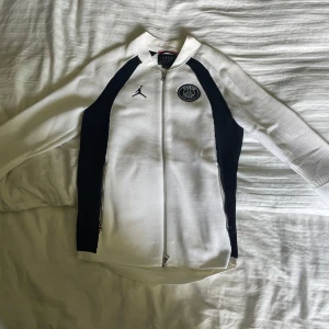 Vit och svart Jordan PSG jacka S - Säljer en snygg vit och svart jacka från Jordan x PSG med dragkedja framtill och två sidofickor. Jackan är limiterad och säljs inte längre vilket gör den exklusivt och har ett högt andrahandsvärde på marknaden . Jackan är i 10/10 skick och har enbart testat. Pris går att förhandla 