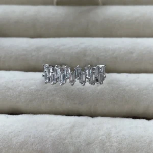 Diamant ringar (2) - Snygg silverfärgad ring med rektangulära, glittrande stenar runt hela bandet. Ringen har en modern och lyxig känsla med sina raka linjer och gnistrande detaljer. Perfekt för dig som vill sticka ut med ett statement-smycke.