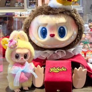 Labubu Let's Checkmate  - En limited färgglad och söt samlarfigur från Pop Mart, klädd i gul och rosa kanindräkt med en krona och stor rosett. Perfekt som accessoar på väskan eller som dekoration. En rolig och trendig detalj för dig som gillar kawaii och unika prylar! Svårt att få tag i, passar på nu och äger en ✅