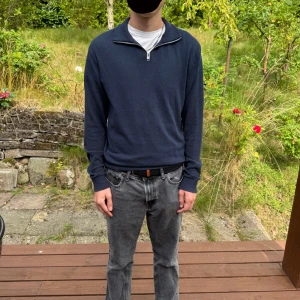 Mörkblå stickad half zip från Jack & Jones - Säljer en mörkblå stickad tröja från Jack & Jones med half zip-dragkedja vid kragen. Tröjan har lång ärm och en klassisk, clean look som funkar till jeans eller chinos. Perfekt för lager-på-lager under hösten eller våren.