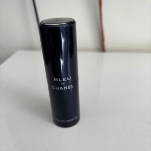 Bleu de Chanel Eau de Parfum (tom flaska) - Snygg och stilren parfym från Chanel, Bleu de Chanel Eau de Parfum. Flaskan är cylinderformad i mörkblått med silverdetaljer och klassisk Chanel-logga på toppen. Perfekt storlek att ta med i väskan och ger en fräsch, maskulin doft.