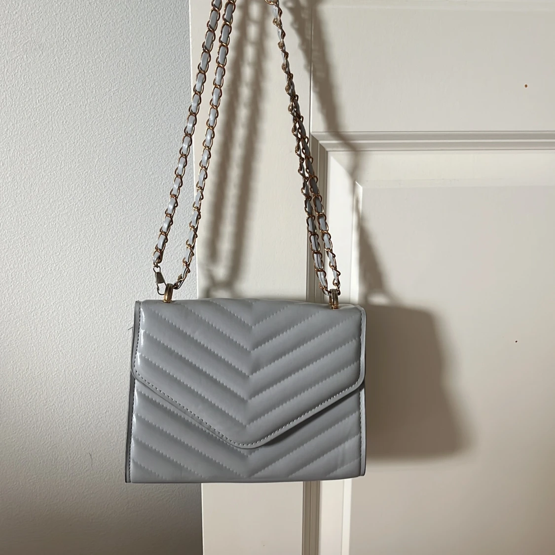 Ljusgrå quiltad axelväska med kedja