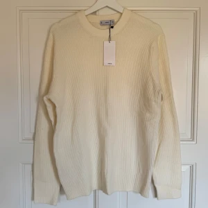 Ribbstickad tröja från Mango - Säljer en helt ny ribbstickad krämvit tröja från Mango i storlek M. Har aldrig använt den så den har kvar prislapp samt att den tyvärr blevit för liten för mig. 