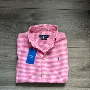 Rosa Ralph Lauren skjorta, ny med prislapp, stl S - Skicka gärna vad du tycker att t-shirten är värd, jag är öppen för bud, skicka gärna ett! Klassisk rosa skjorta från Ralph Lauren i storlek S, helt ny med original prislapp kvar, aldrig använd. Ett stilrent plagg i riktigt fin kvalitet som passar både till vardags och mer uppklätt. Nypris ca 1 200 kr, här har du chans att få den till ett mycket bättre pris, 499kr. Kika gärna in min profil, jag lägger upp liknande plagg löpande! Ralph Lauren skjorta rosa ny oanvänd skjorta med tagg herrskjorta sl