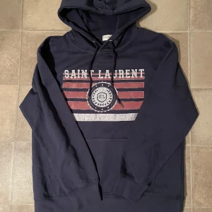Mörkblå Saint Laurent Hoodie - Tjenare, säljer en Saint Laurent Hoodie i storlek M som är i super bra skick. Skriv om du har frågor✌️