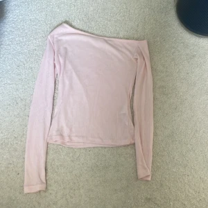 Ljusrosa offshoulder tröja Gina Tricot - Supersöt ljusrosa offshoulder tröja från Gina Tricot i ribbad, tunn stickad kvalitet. Långärmad och perfekt för dig som gillar en feminin och trendig look. Passar snyggt till både jeans och kjol. Bara andvänt en gång