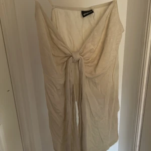 Beige blus från Gina Tricot - Supersnygg beige blus från Gina Tricot i mjukt och lätt material. Blusen har knyt framtill som ger en trendig look och passar perfekt till varma dagar. Enkel att styla med kjolar eller shorts för en chill vibe.