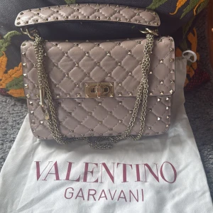 Beige quiltad handväska Valentino - Säljer en beige/rosa rockstud spike bag från Valentino Garavani ❣️. Superfint skick och kvitto finns ❣️❣️nypris är 32 075kr❣️