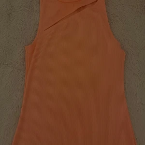 Persikofärgad klänning från H&M🧡 - Säljer en persikofärgad ribbad klänning från H&M. Klänningen är ärmlös och har en tight passform. Perfekt för dig som gillar en enkel men trendig stil. Säljer den pågrund av att den kommer inte till användning för mig,köptes för ca 400kr. Pris kan diskuteras och den passar xs också🧡