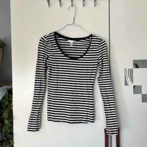 Svartvit randig långärmad tröja från H&M - Säljer en svartvit randig långärmad tröja från H&M. Tröjan har en rundad halsringning och är i ett mjukt, stretchigt material som sitter tight. Perfekt att styla med jeans eller kjol.