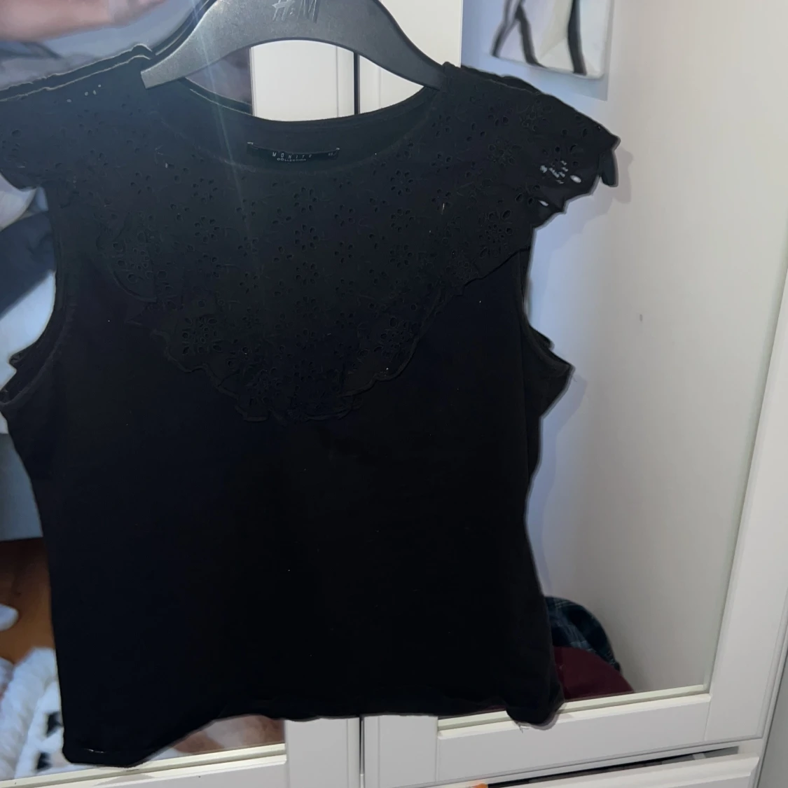 Svart ärmlös topp med spetsdetaljer