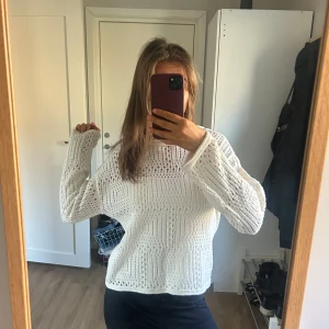 Vit stickad tröja med hålmönster - Säljer en vit stickad tröja med hålmönster och lång ärm. Tröjan har en avslappnad passform. Andvänd en gång, så super fin 